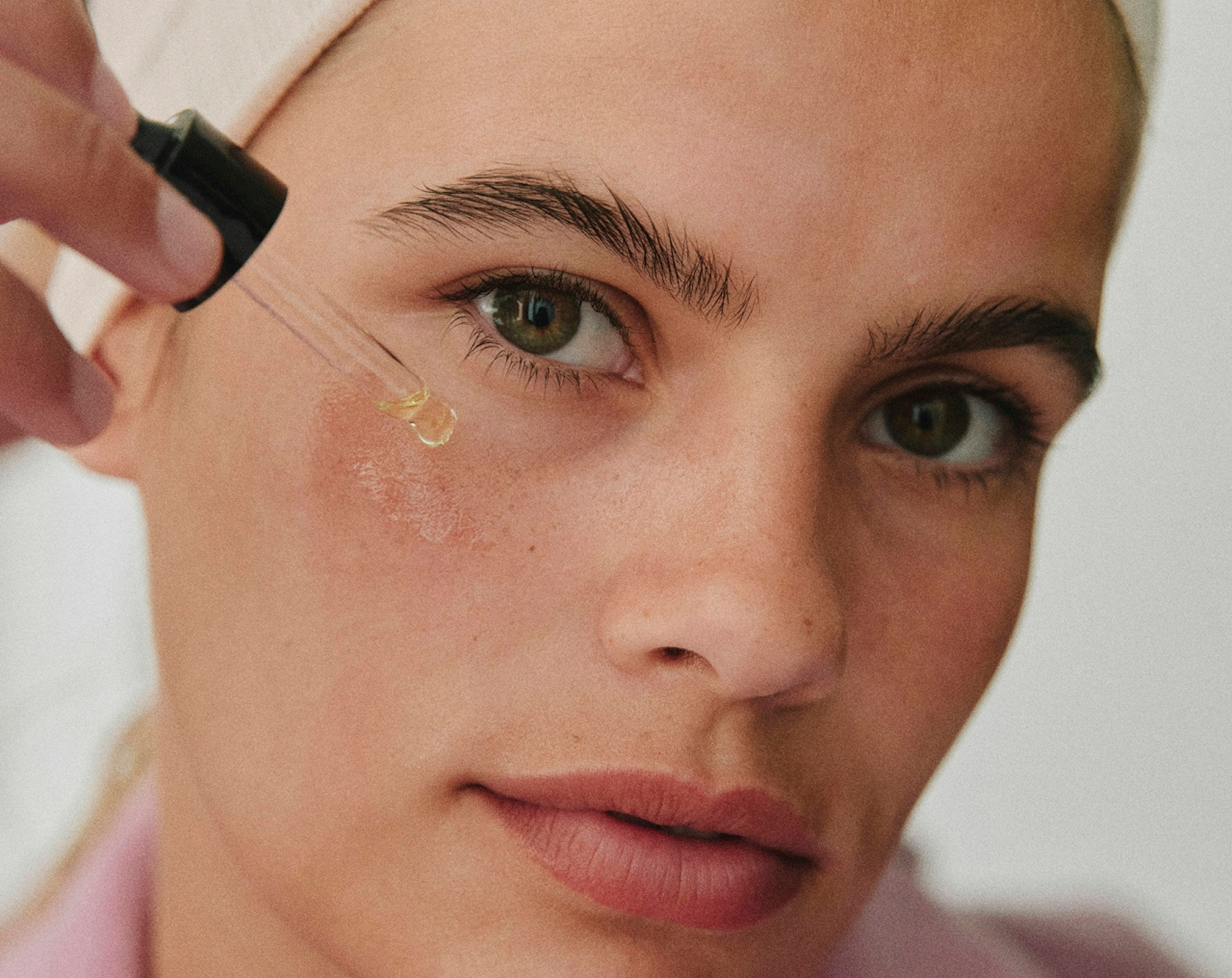 Concentré à la Rose Noire Sisley sérum con textura rosada aplicado sobre la piel