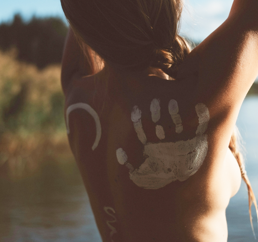 Espalda femenina con pintura blanca en forma de mano simbolizando cuerpo, memoria y experiencia en endometriosis síntomas diagnóstico