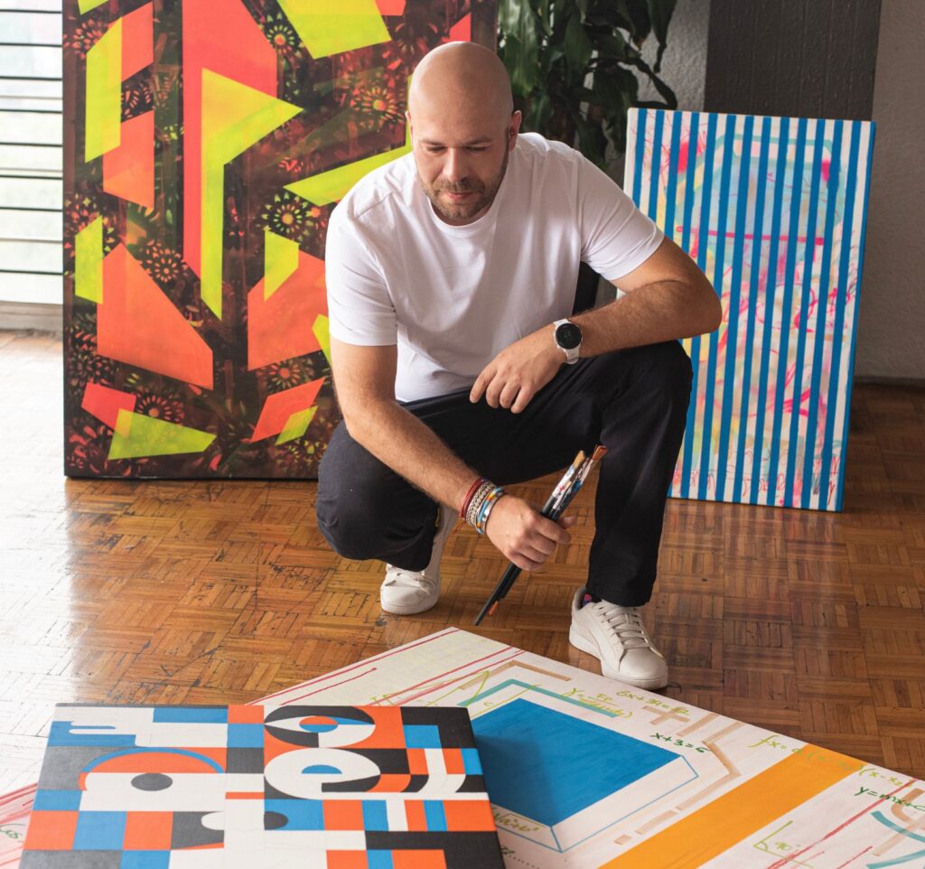 Miguel González observing his artworks in the studio where AWOK's visual universe takes shape.