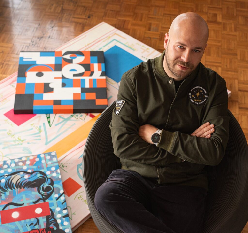 Portrait of AWOK alongside several of his paintings, reflecting his visual language between design, art, and identity.